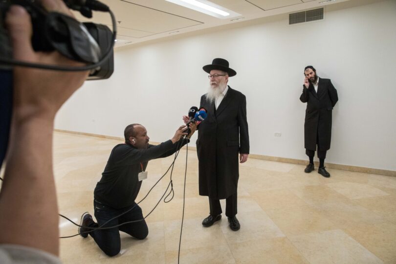 יעקב ליצמן מתראיין לתקשורת בכנסת ב-2020, כשהחזיק בתיק הבריאות. מאחור: עוזרו הבכיר מוטי בבצ'יק (צילום: יונתן זינדל)