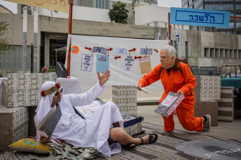מיצג מחאה המדמה את שיתוף הפעולה בין בנימין נתניהו לקטאר. צולם מחוץ לבית המשפט המחוזי בתל-אביב באפריל 2025, באחד מימי הדיונים במשפטו הפלילי של ראש הממשלה (צילום: מרים אלסטר, פלאש 90)