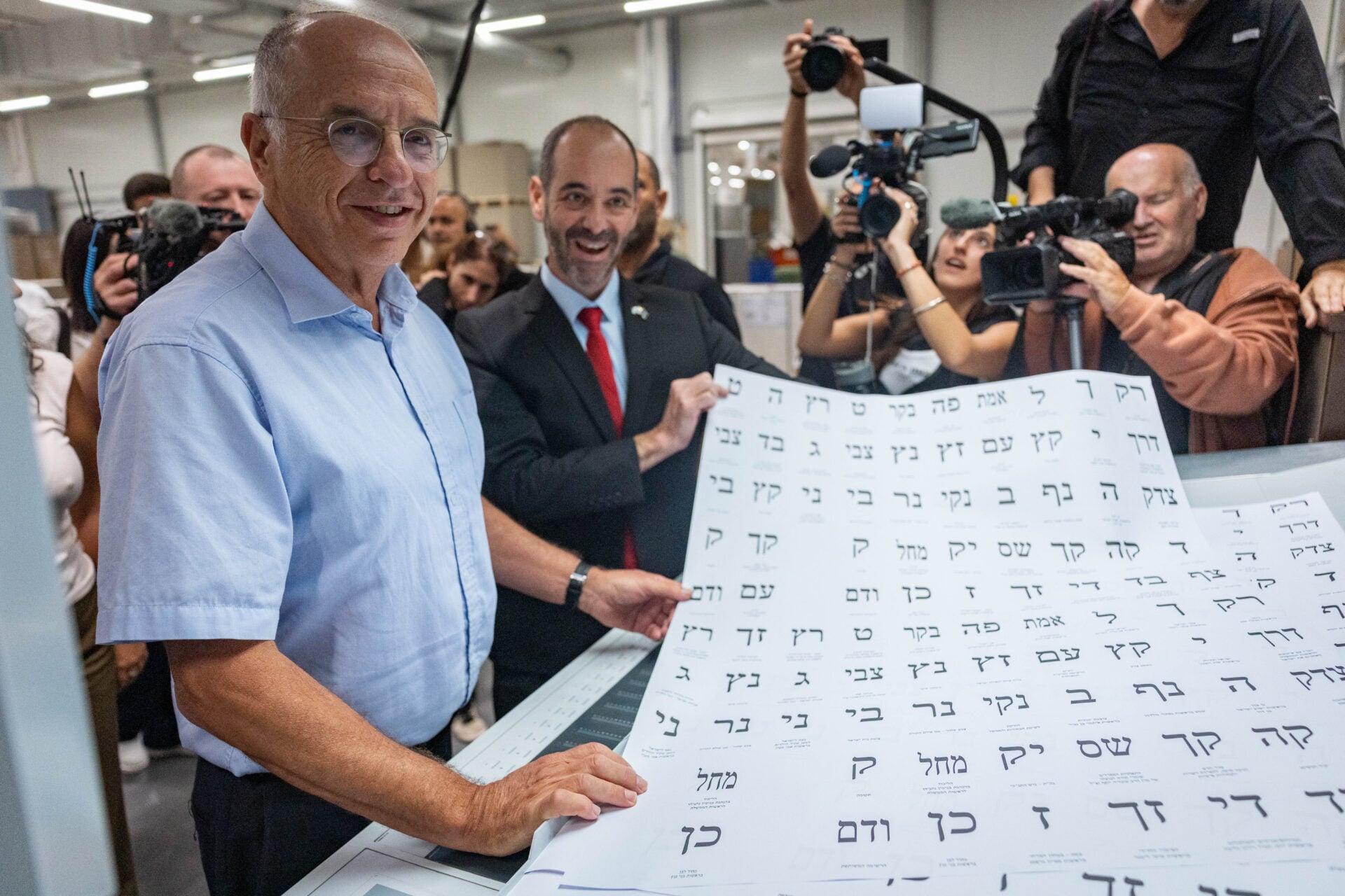 יו"ר ועדת הבחירות השופט נועם סולברג (משמאל), בוחן פתקי הצבעה במפעל בקריית-גת, אוקטובר 2026 (צילום: יונתן זינדל)